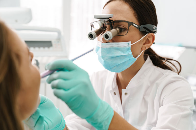 dentist using tools to examine a dental implant
